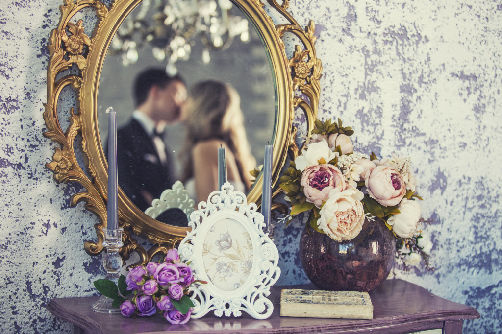 Vintage mirror with the bride and groom in the reflection on the wedding day